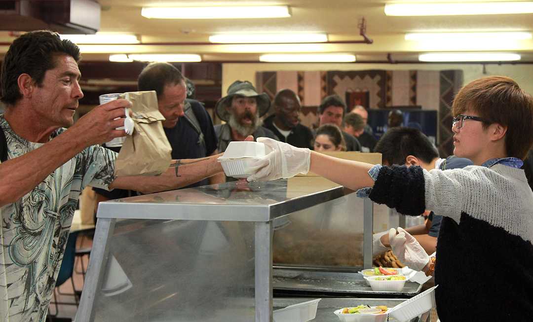 Volunteer and charity club serves food at homeless shelter The Channels