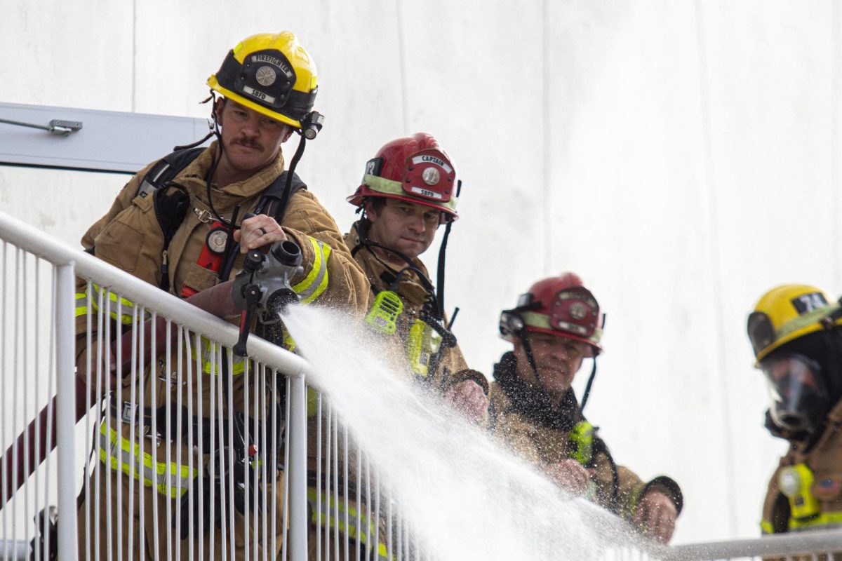 Shane Wallace showers water from the second story of the West Campus Center on Oct. 26 at City College in Santa Barbara, Calif. "Just pride and serving the community...my father was a firefighter," Wallace said.