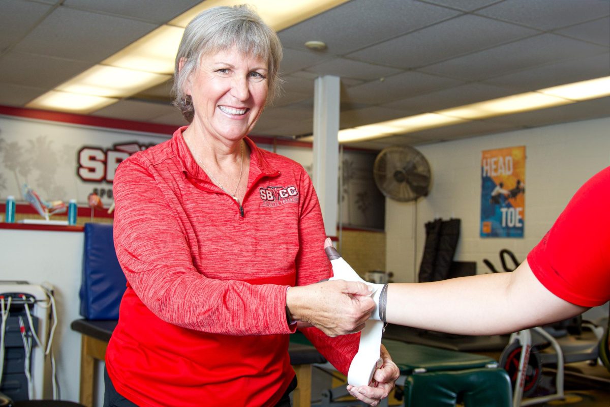 Sue Houlihan-Davis joyfully wraps the thumb of an athlete with athletic tape on Oct. 8 in the athletic training room at City College in Santa Barbara, Calif. "It's really rewarding to see somebody come from not being able to participate to being able to get back on the field and do what they love," Houlihan-Davis said.