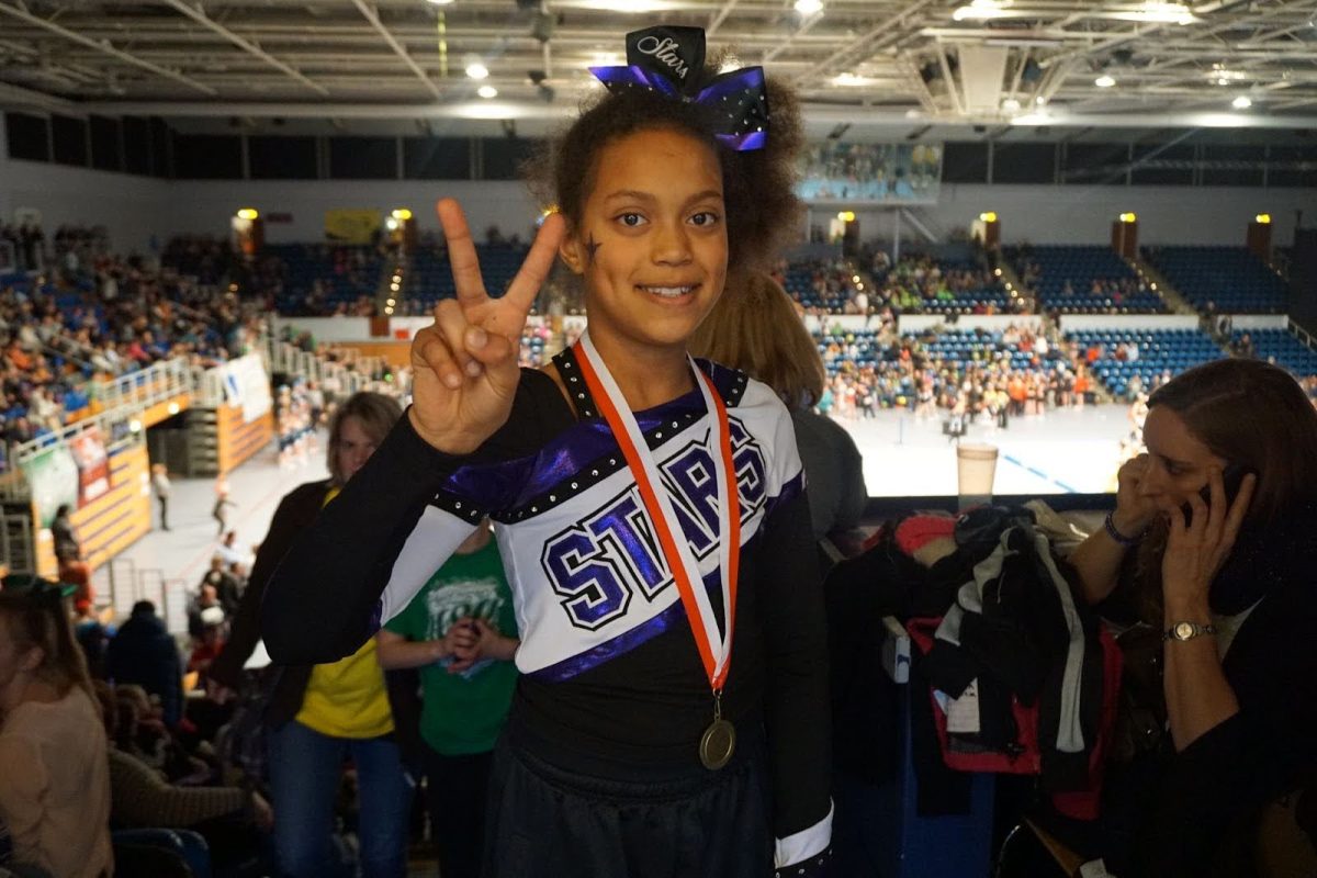 Rodeck smiling at her dad taking a picture of her at a competition in 2015. She and her team just got announced as first place