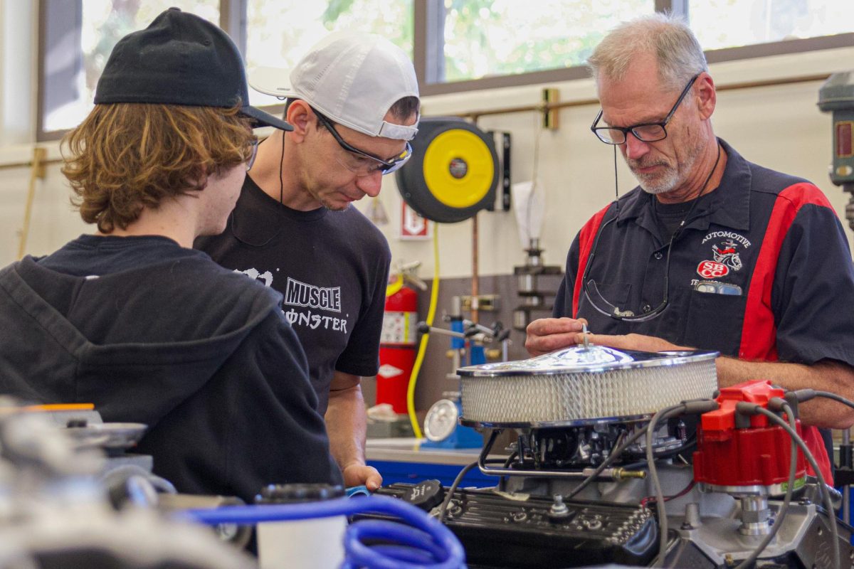 From left, Keanu De Witt, Cesar Carranza and Instructor Dave Brainerd work together to put an air filter on the engine on Nov. 6 in the automotive shop at City College in Santa Barbara, Calif. "I think it's just a super fun experience and it's a great learning opportunity," De Witt said.